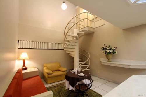 圣若昂-德雷维琴察公寓式酒店的客厅设有螺旋楼梯和椅子