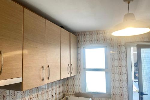 EspinardoGuest house Croqueta Espinardo的厨房配有木制橱柜和窗户。