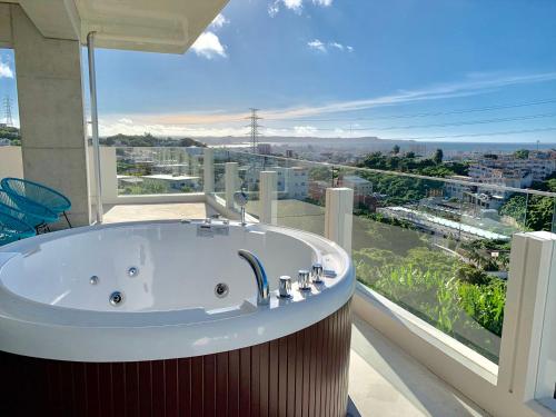 冲绳岛市CONDOMINIUM 紅-BIN-的带浴缸的浴室和大窗户
