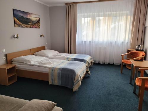 维斯瓦Hotel *** NAT Wisła的酒店客房设有两张床和窗户。