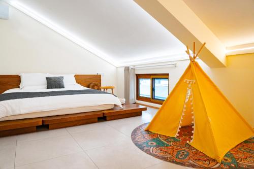 杭州一尘三舍的一间卧室配有一张床和一个黄色的帐篷