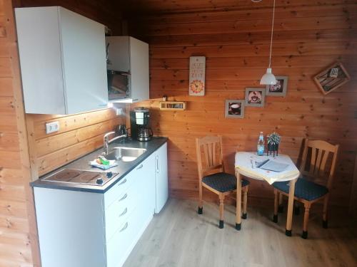 SehlenFerienwohnung“puutalossa“的厨房配有水槽和桌椅