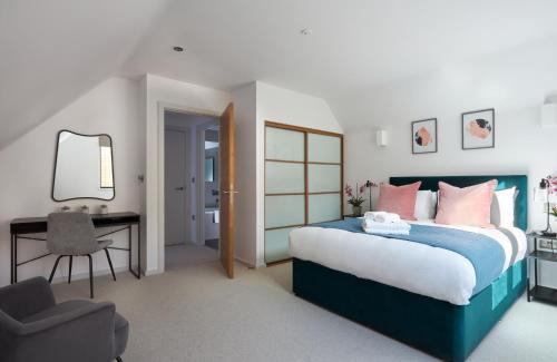 伦敦Hammersmith Mews by Viridian Apartments的一间卧室配有一张床、一张桌子和一把椅子