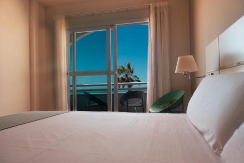 奇皮奥纳Hotel Vértice Chipiona Mar的一间卧室设有一张床和一个美景窗户。