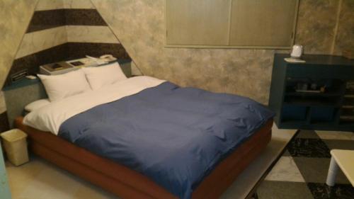 AsahiHotel Sekitei的一间卧室配有一张带蓝色毯子的床