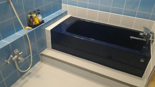 AsahiHotel Sekitei的蓝色瓷砖浴室设有水槽