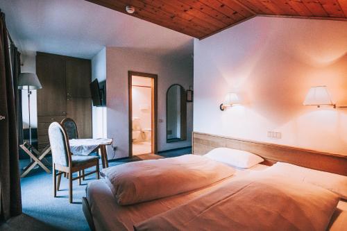 科瓦拉因巴迪亚Hotel Planac的卧室配有1张床、1张桌子和1把椅子
