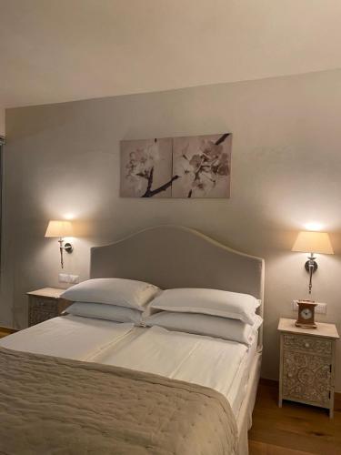 利莫内-苏尔加达Casa L'Andrunèl的一间卧室配有一张带两张桌子和两盏灯的床。