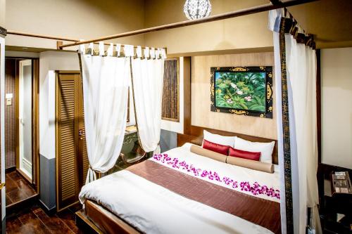 东京Hotel Balian Resort Kinshicho的一间卧室配有一张带红色枕头的天蓬床