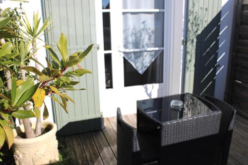 Loix花音酒店的一个带黑色桌子、椅子和植物的门廊