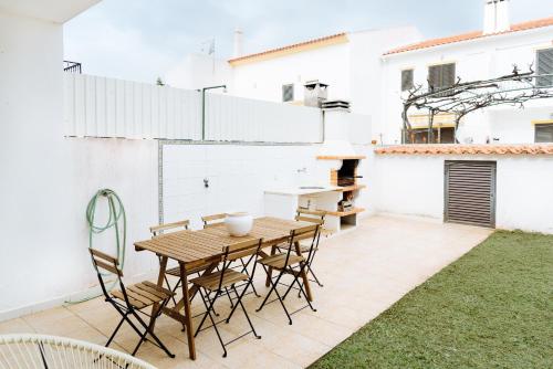 阿尔图拉Altura Beach Villa by GT House的庭院配有木桌和椅子