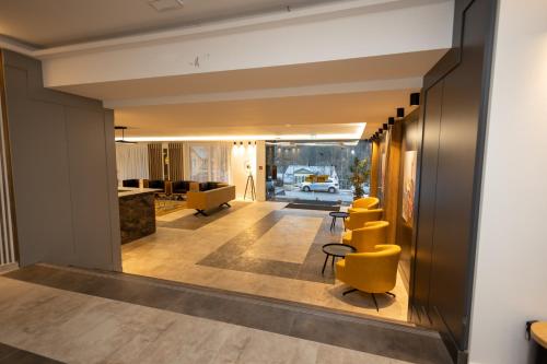 施朗根巴特Hotel Schlangenbader Hof的走廊设有黄色椅子和客厅