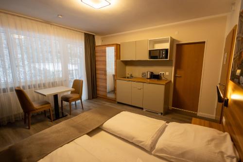 施朗根巴特Hotel Schlangenbader Hof的酒店客房设有一张床铺、一张桌子和一间厨房。