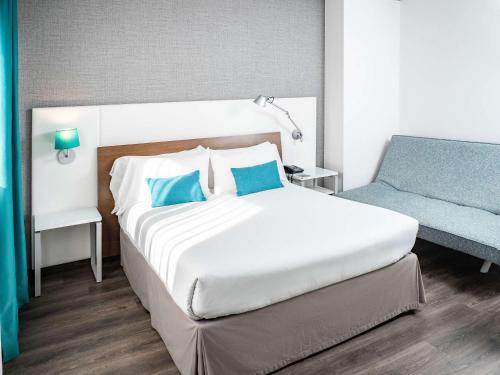 拉科鲁尼亚拉科鲁尼亚宜必思尚品酒店的卧室配有白色的床和蓝色椅子