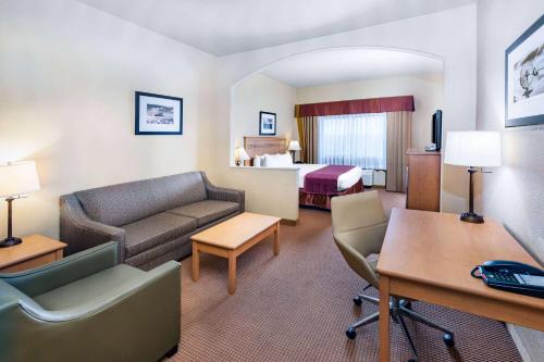 CueroBaymont by Wyndham Cuero的酒店客房设有一张沙发和一张床