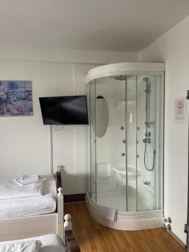 特罗辛根Linde Restaurant & Hotel的一间带玻璃淋浴的浴室和一张床