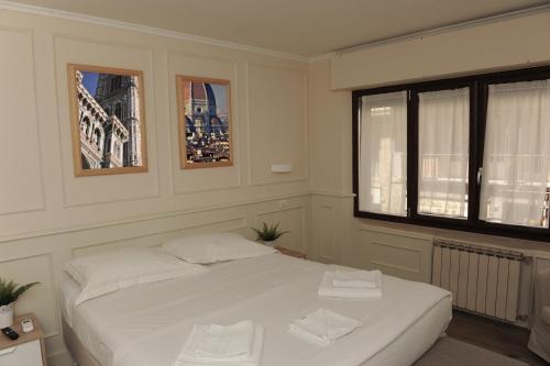 佛罗伦萨pontevecchio rooms的卧室配有白色的床和2条毛巾