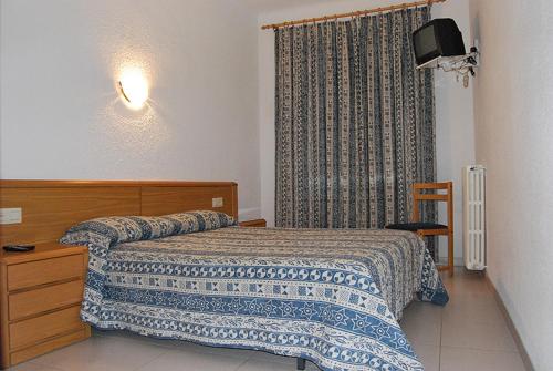 兰卡Hostal Gran Sol的一间卧室配有一张床、一个梳妆台和一扇窗户。