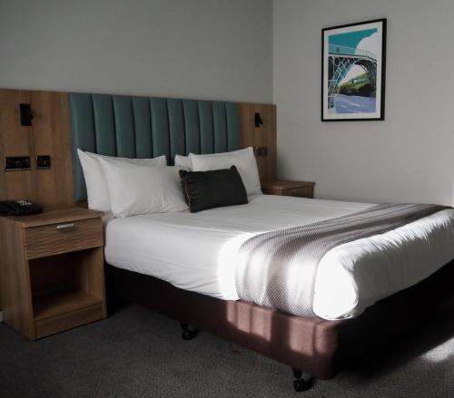 特尔福德假日特尔福德铁桥酒店的一间卧室配有一张大床和绿色床头板