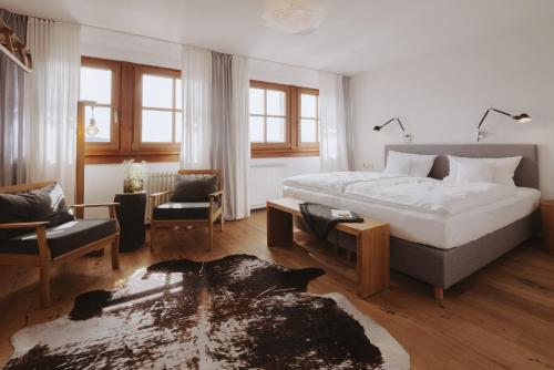 圣玛尔根德尔赫尔申旅馆的一间卧室设有一张床和一间客厅。