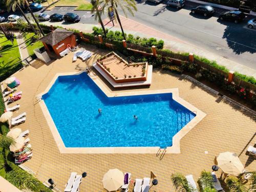 卡内拉岛Apartment Los Gavilanes的游泳池的顶部景色,其中有2人