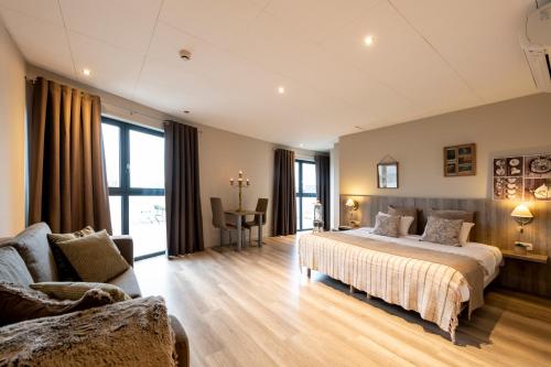 Melen德拉图尔酒店的一间大卧室,配有一张床和一张沙发