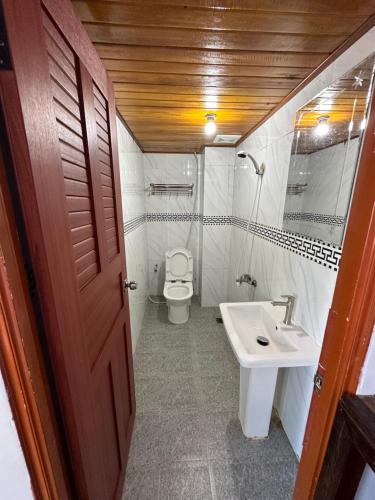 瓜隆岛Roomy Guesthouse的一间带卫生间和水槽的小浴室