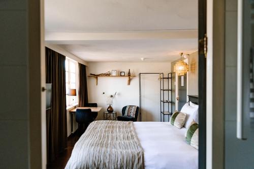 霍赫苏伦Boutique Hotel Hoog Soeren的配有一张床和一张书桌的酒店客房