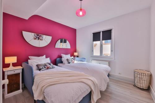 蒙斯特Le Moderne Vintage Hyper Centre, vue cigognes, montagne, neuf au calme, 3 étoiles的配有两张床的带粉红色墙壁的客房