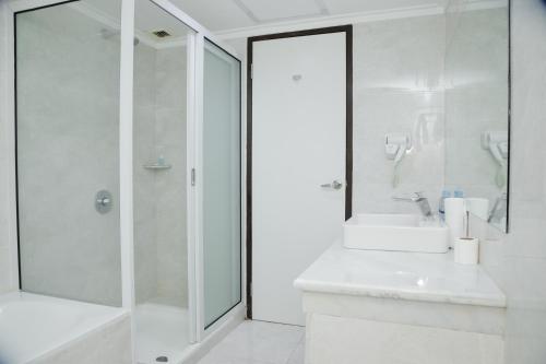 棉兰棉兰大酒店的白色的浴室设有水槽和淋浴。