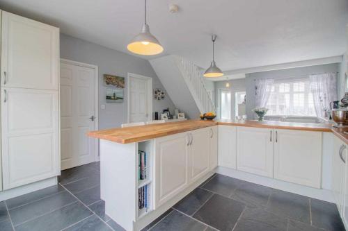 比斯顿Pear Tree House的厨房配有白色橱柜和瓷砖地板。
