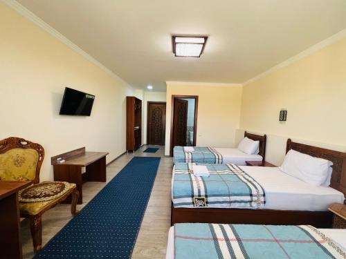 布哈拉2nd floor的酒店客房设有三张床和电视。