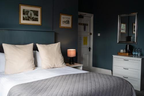 温彻斯特普拉夫伊坎阿巴斯宾馆的一间卧室配有一张蓝色墙壁的床