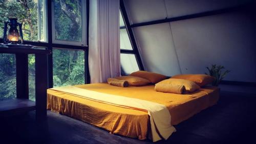 RattotaRiverston Nature Villa的一间卧室配有一张带黄色床单和枕头的床。