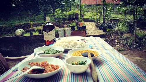 RattotaRiverston Nature Villa的餐桌,餐碗和一瓶葡萄酒