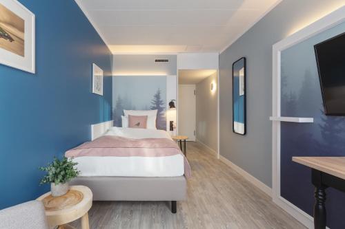 埃森Yggotel Solsort的一间卧室配有一张蓝色墙壁的床