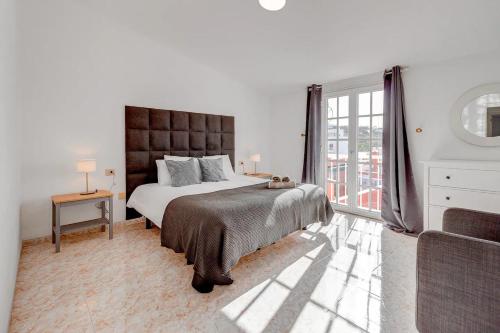 圣胡安海滩Bonita Casa Nina的一间卧室设有一张大床和一个大窗户