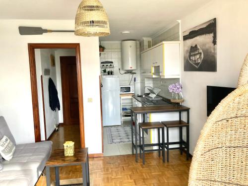 里瓦德塞利亚Rincon en el Rio Sella的厨房以及带桌子和冰箱的客厅。