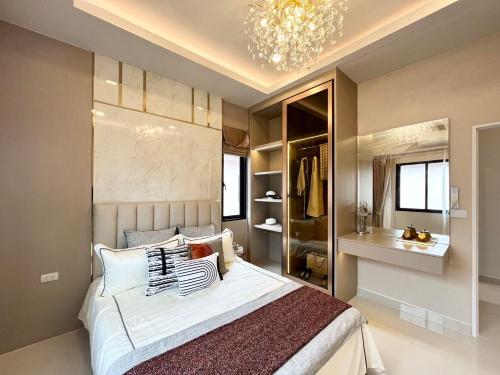 班怀雅Southern Peak Pool Villa Huay Yai Pattaya的一间卧室配有一张大床和一个吊灯。