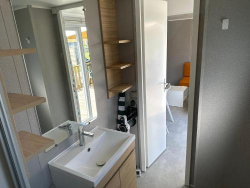 圣乔治-德迪多讷mobil home 6 places tout confort的一间带水槽和镜子的浴室