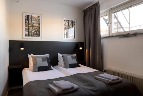 莫拉Hotel Bishops Arms Mora的一间卧室设有两张床和两个窗户。