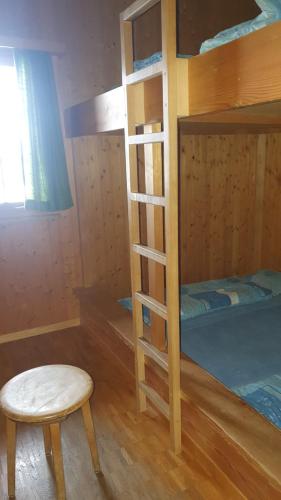 埃尔姆Skihütte Obererbs的一间卧室配有双层床、凳子和椅子