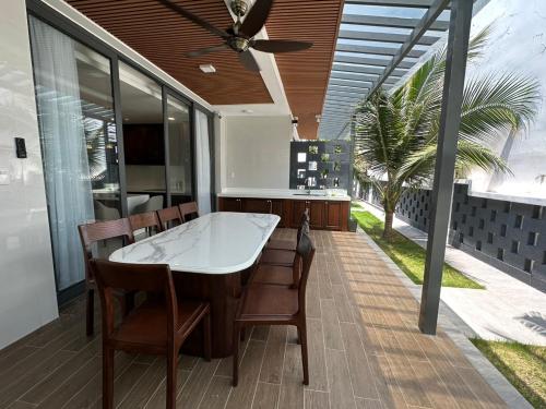 隆海Oceanami Villa Long Hải - Vũng Tàu的厨房配有带桌椅的甲板