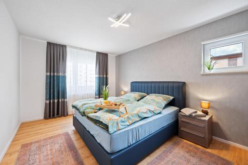 莱茵河畔路德维希港Minty Lounge的一间卧室配有一张蓝色的床,上面有桌子