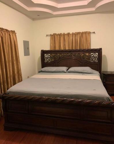 圣费尔南多Comfortable home in San Fernando的一间卧室配有一张木架大床