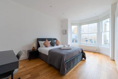 伦敦Trendy East London Flat BRO1的一间白色卧室,配有一张床和一架钢琴