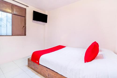 圣克里斯托瓦尔-德拉斯卡萨斯OYO Hotel La Luna的卧室配有白色的床、红色枕头和窗户