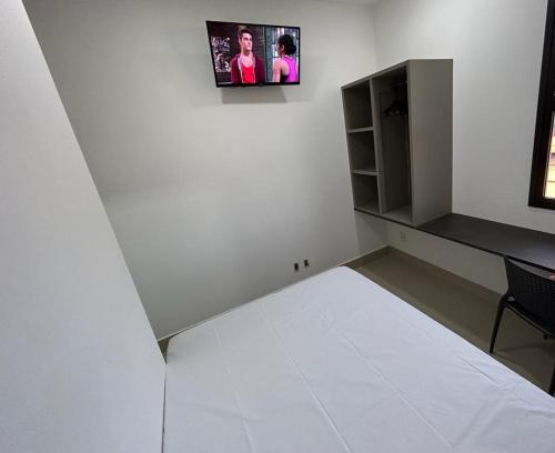 乌贝兰迪亚NANO Suítes的白色的客房配有一张床和一张书桌