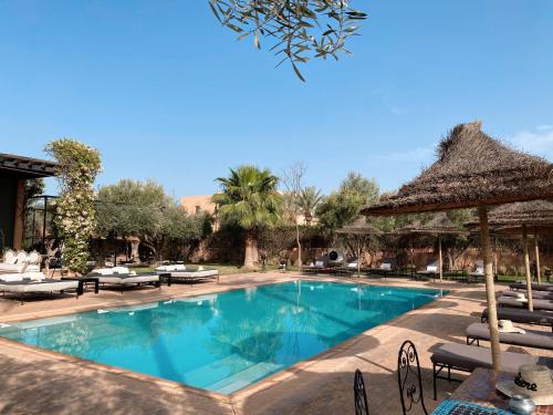 马拉喀什Villa Singulière By Louhou Collection的度假村的游泳池配有椅子和遮阳伞