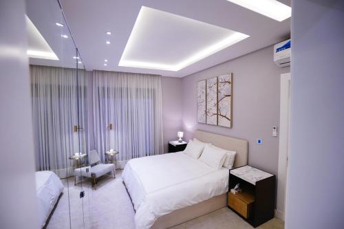 利雅德Spacious and Modern Apartment for Rent in Ergah, Riyadh的卧室配有一张白色大床和一把椅子
